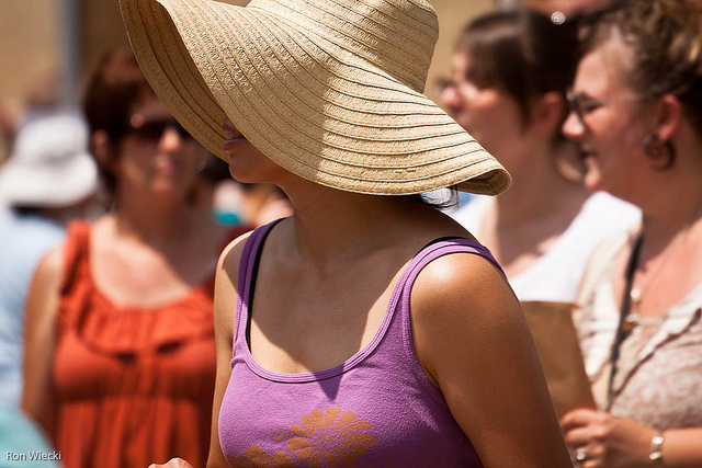 A woman wears a wide brim hat in the sun. Photo by Ron Wiecki/CC, Flickr
